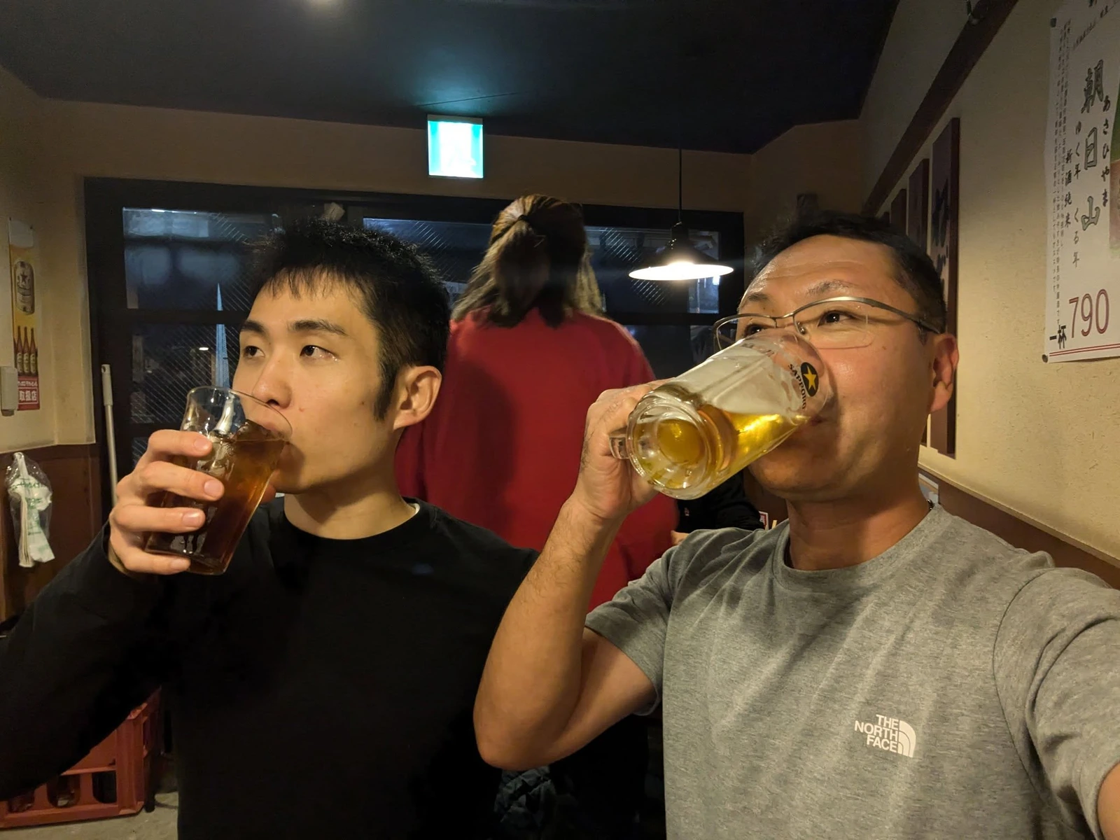 飲食店で乾杯する坂根崇真(左)と大峯光宏(右)